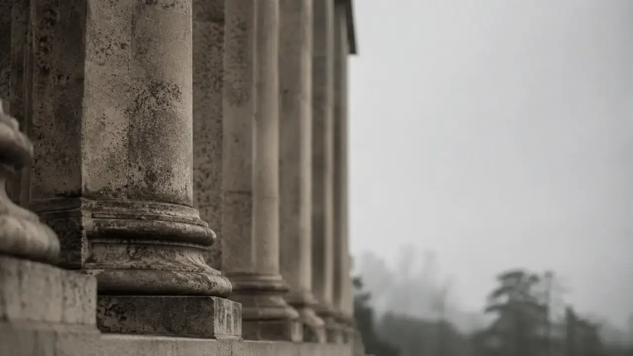 Stone columns of a federal research institution in muted morning light, representing the public infrastructure that supports trauma science.